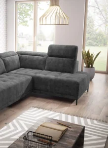 Nowoczesna szara sofa tapicerowana w stylowym wnętrzu salonu