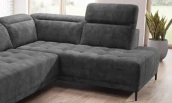 Nowoczesna sofa tapicerowana w jasnym salonie z dekoracyjnym stolikiem i roślinami