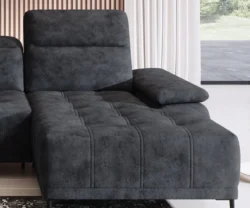 Nowoczesna szara sofa tapicerowana w stylowym salonie z jasnymi ścianami i dekoracjami
