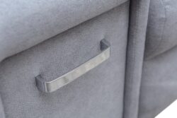 Detal narożnika rozkładanego Arni w tkaninie Aston-16 z chromowanymi nóżkami i poduszkami dekoracyjnymi