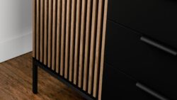 Komoda Meorati z frezowanymi frontami w kolorze dąb artisan i czarnym korpusem na metalowych nóżkach