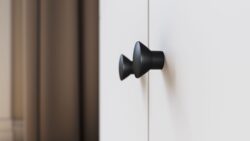 Biała trzydrzwiowa szafa uchylna Dullum z czarnymi uchwytami do nowoczesnego wnętrza