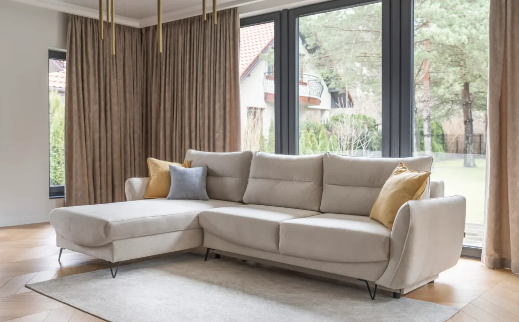 Narożnik rozkładany Silva w tkaninie Manhattan-18 z pojemnikiem na pościel na tle jasnego wnętrza