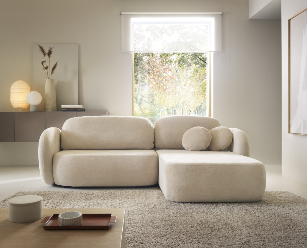 Narożnik rozkładany Olio w nowoczesnym salonie z jasną tapicerką i pojemnikiem na pościel
